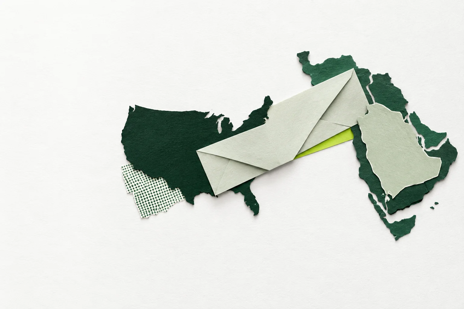 Paper-collage envelope connecting map silhouettes of the United States and the Arabian Peninsula